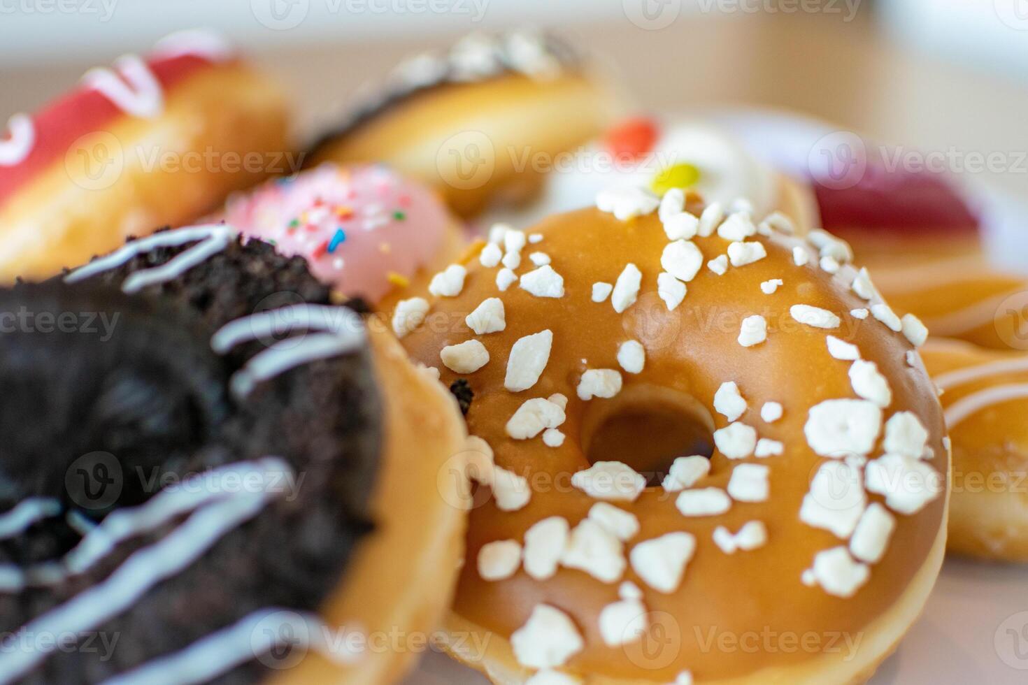 a close up macro image of a selection of flavoured doughnuts photo