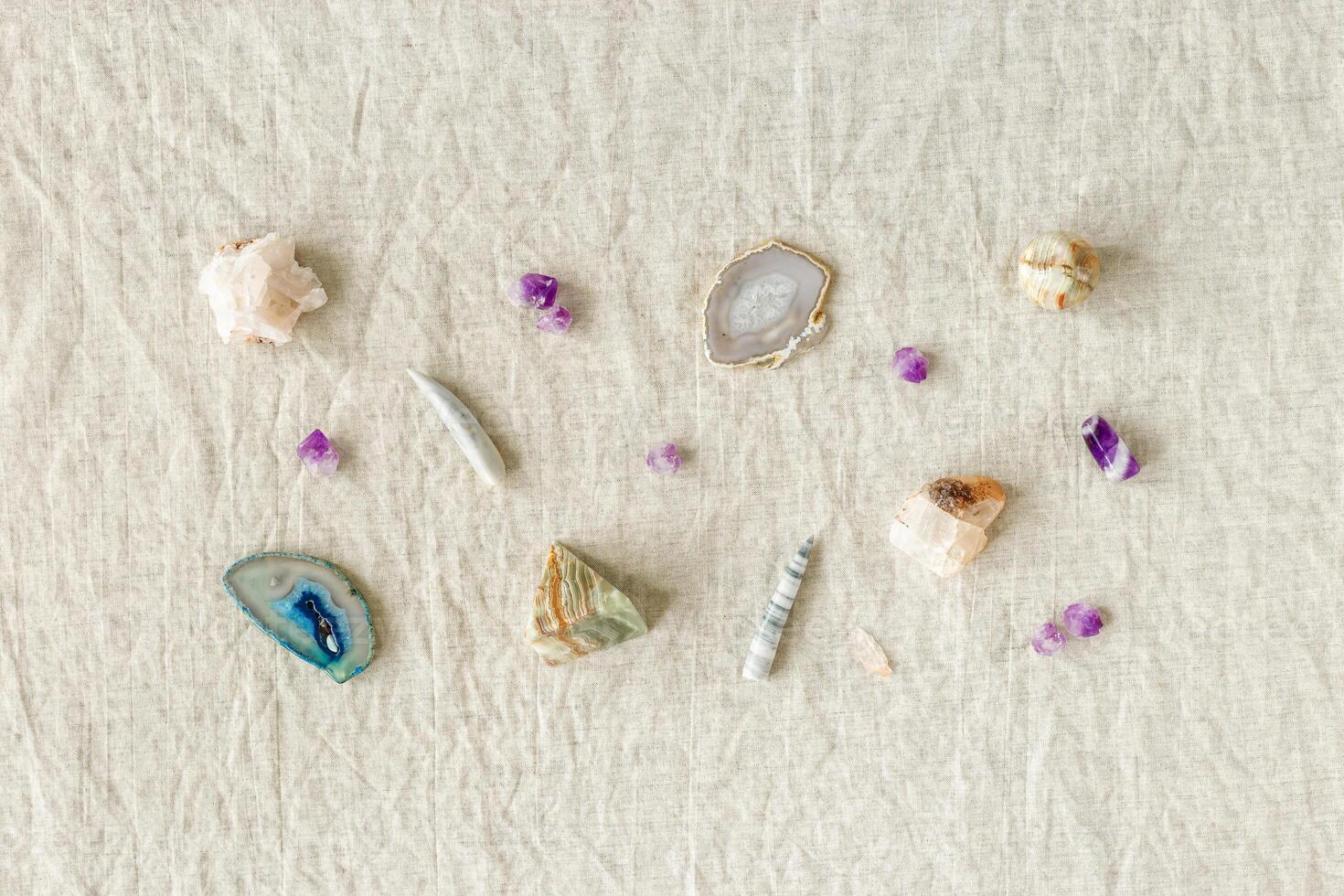 Pattern of crystals on table, healing minerals agate, quartz, amethyst, onyx, semiprecious gem. Stones for stone therapy, lithotherapy, rocks for ritual. Top view, minimal flat lay, photo