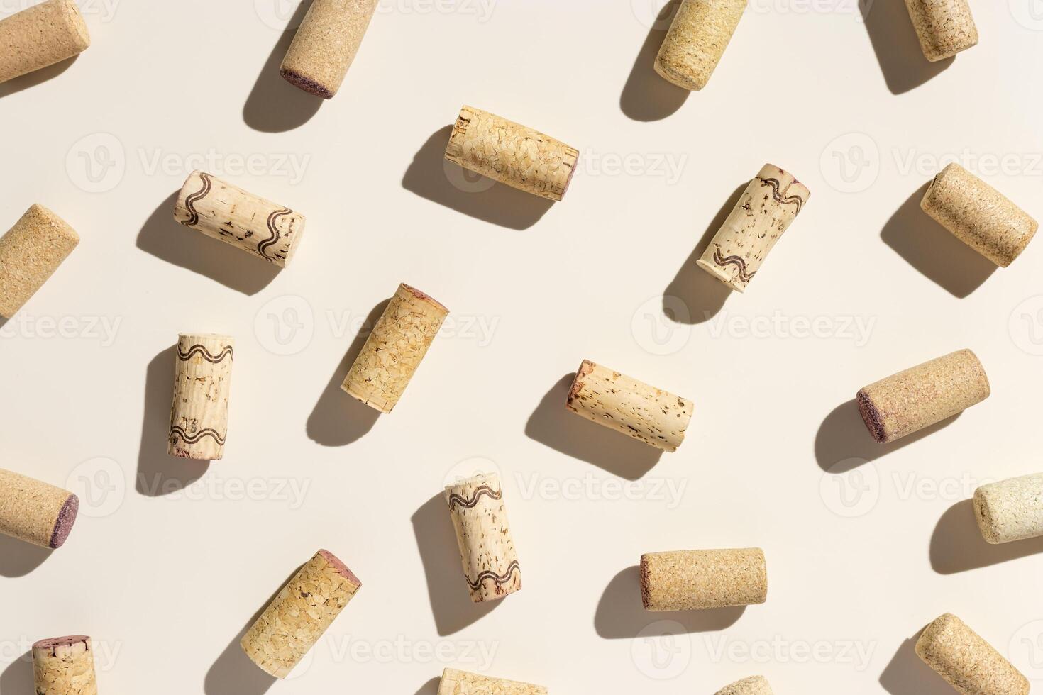 Pattern with wine corks from white and red wine on beige pastel color background with shadow at sunlight. Trend layout with bottle cap wooden cork, top view, minimal flat lay photo