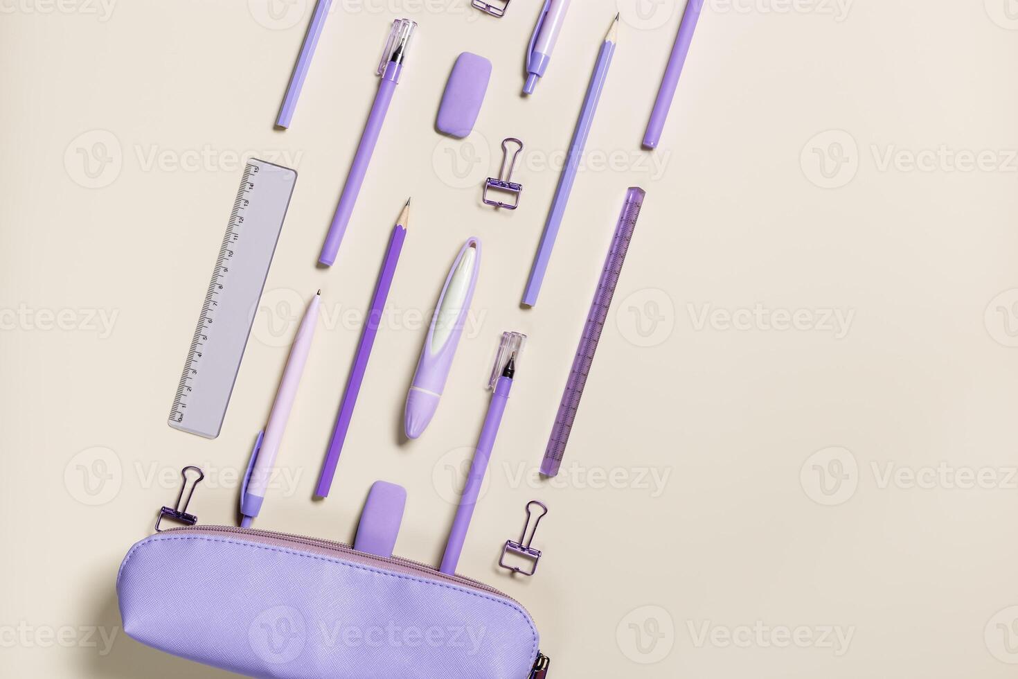Office supplies very peri trend color of year, pencils, pens, paper clips, erasers fly from pencil case. School stationery flat lay on table. Back to school pattern on beige background. Copy space photo