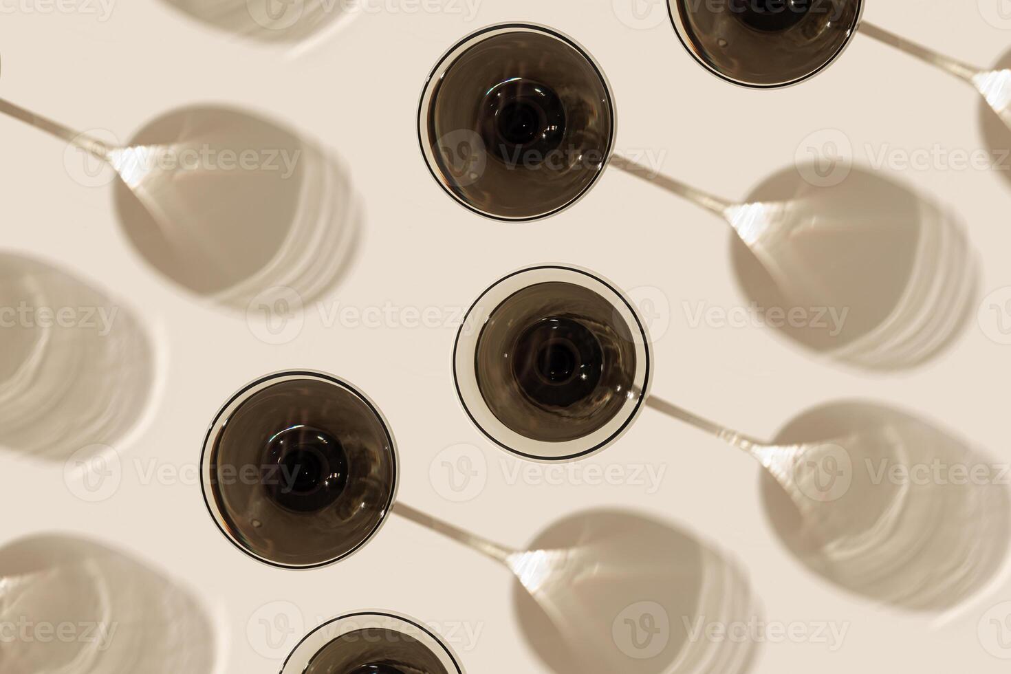 Champagne glasses from gray glass on beige background as creative geometric pattern, with beautiful shadows and caustics from sun. Summer light drinks. Wine glass, top view vintage glassware photo