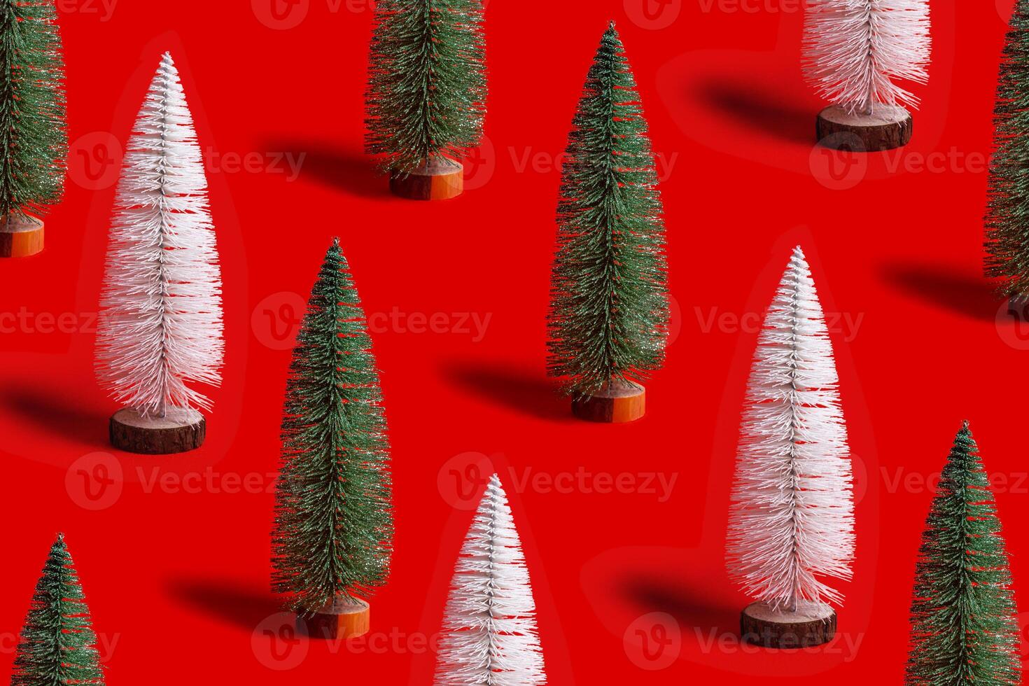 Pattern of shining Christmas tree white and green color on red background. Minimal New Year layout with mini festive fir, xmas decor ornament, winter holiday concept photo
