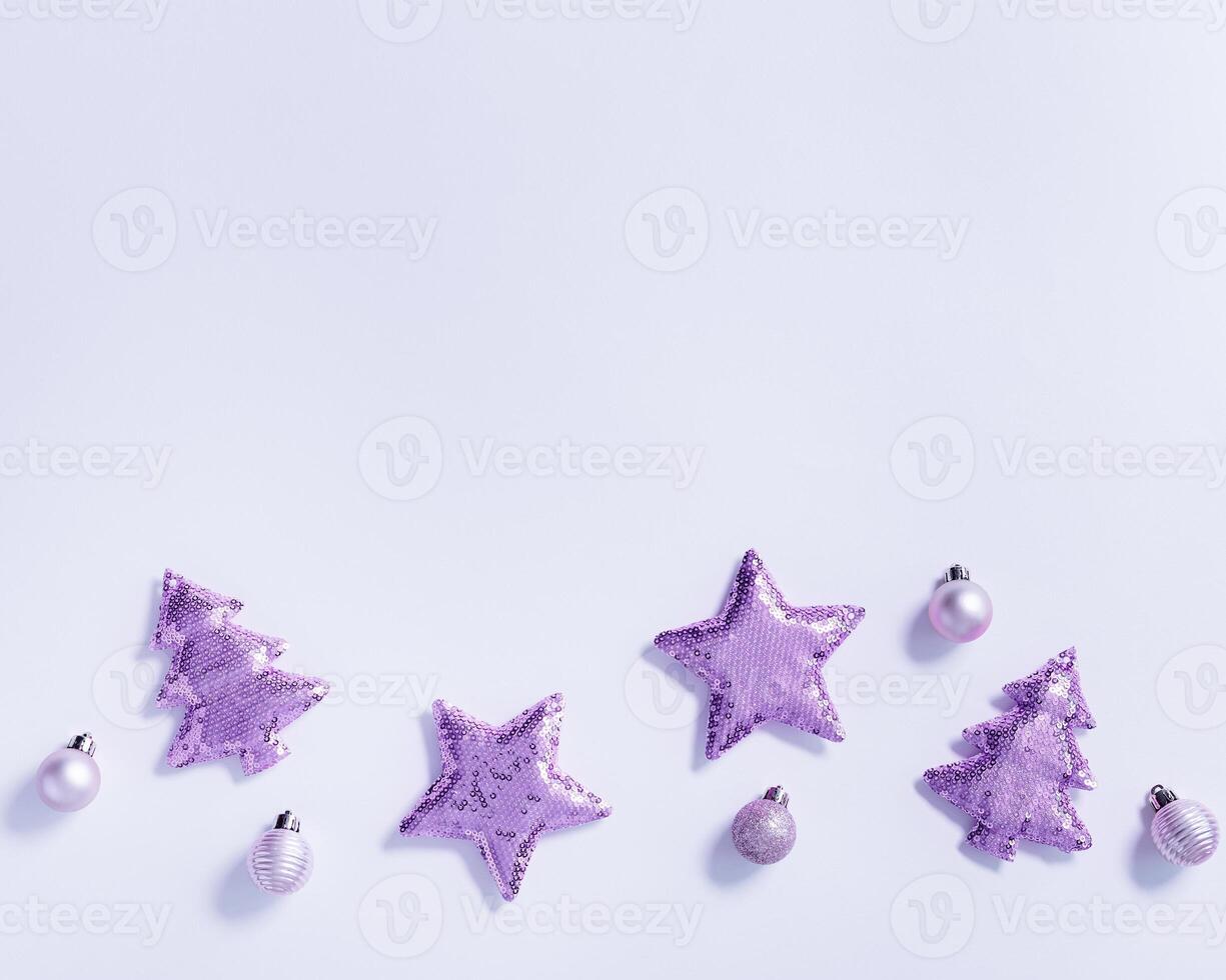 Christmas background with shining lavender color soft toys with sequins, shape Christmas fir tree and star, monochrome image. New Year holiday greeting card, invitation, trend color photo
