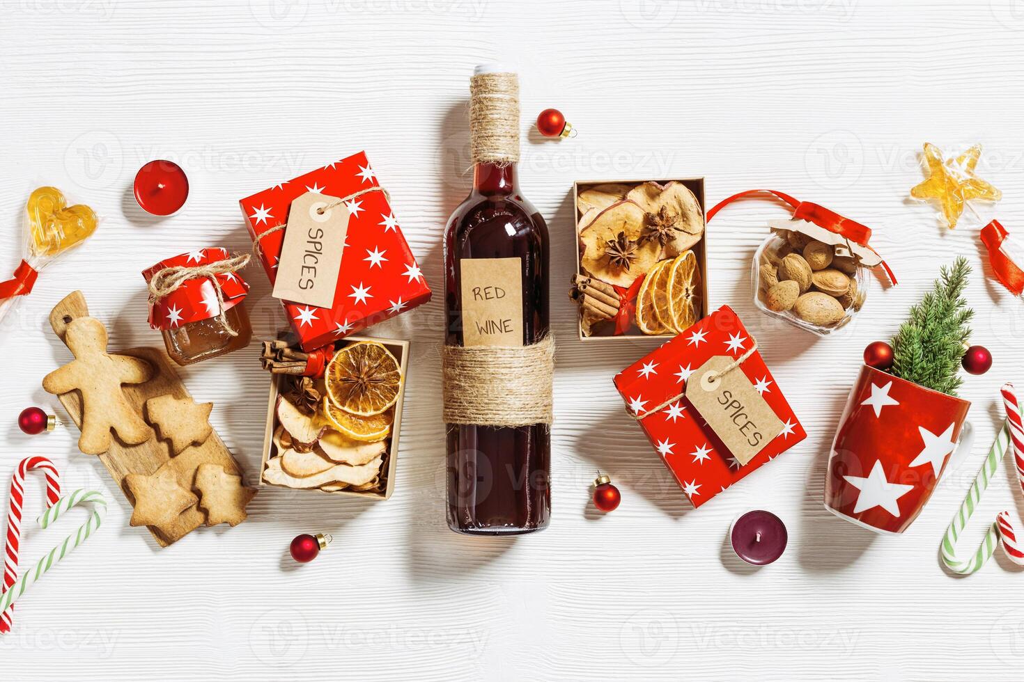 Christmas flat lay with Mulled wine Ingredients. Bottle red wine, red mug, paper gift box with spices, Christmas cookies Preparation diy presents for winter holidays photo