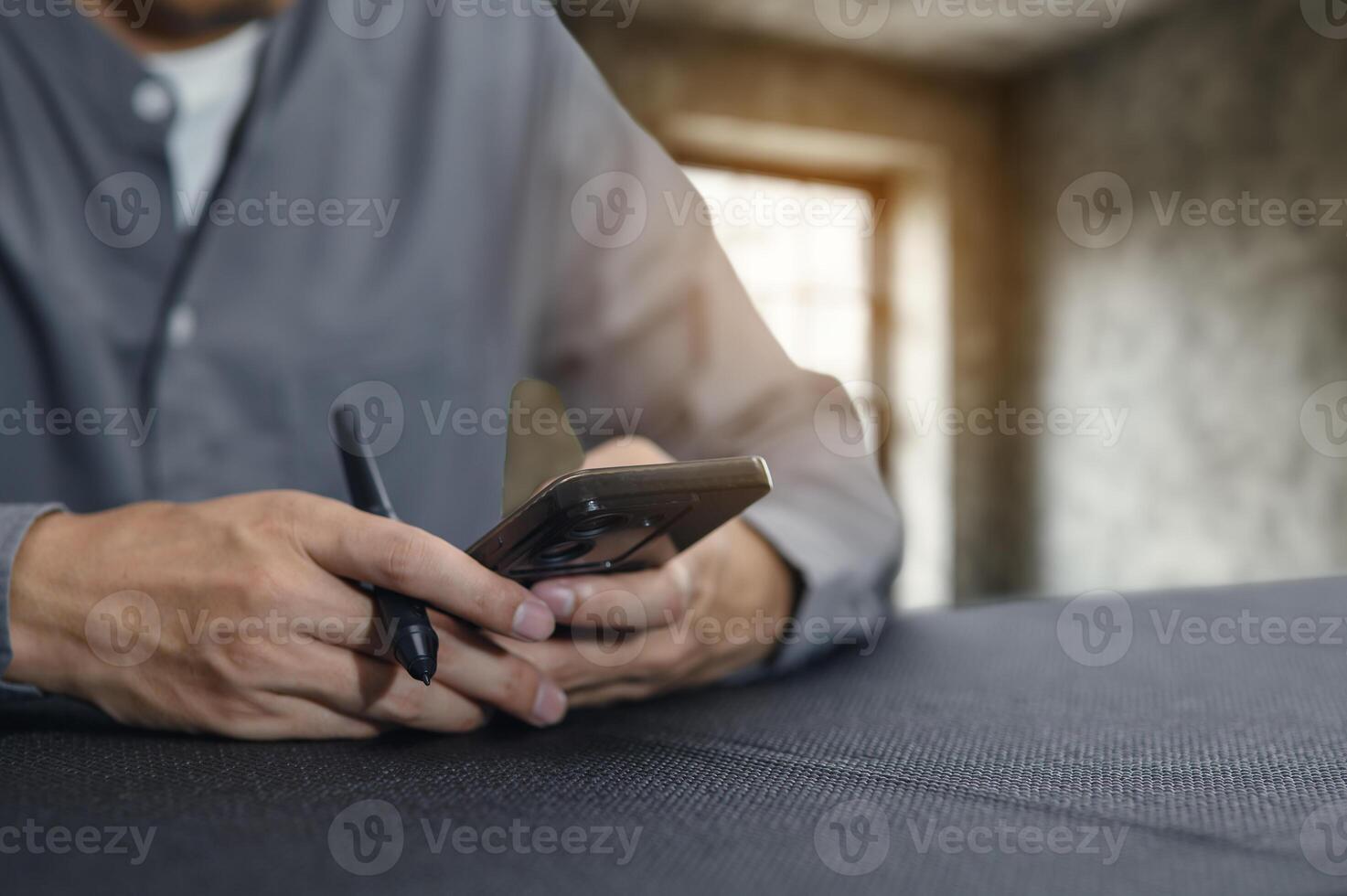 Person Using Smartphone with Pen in a Modern Indoor Setting photo
