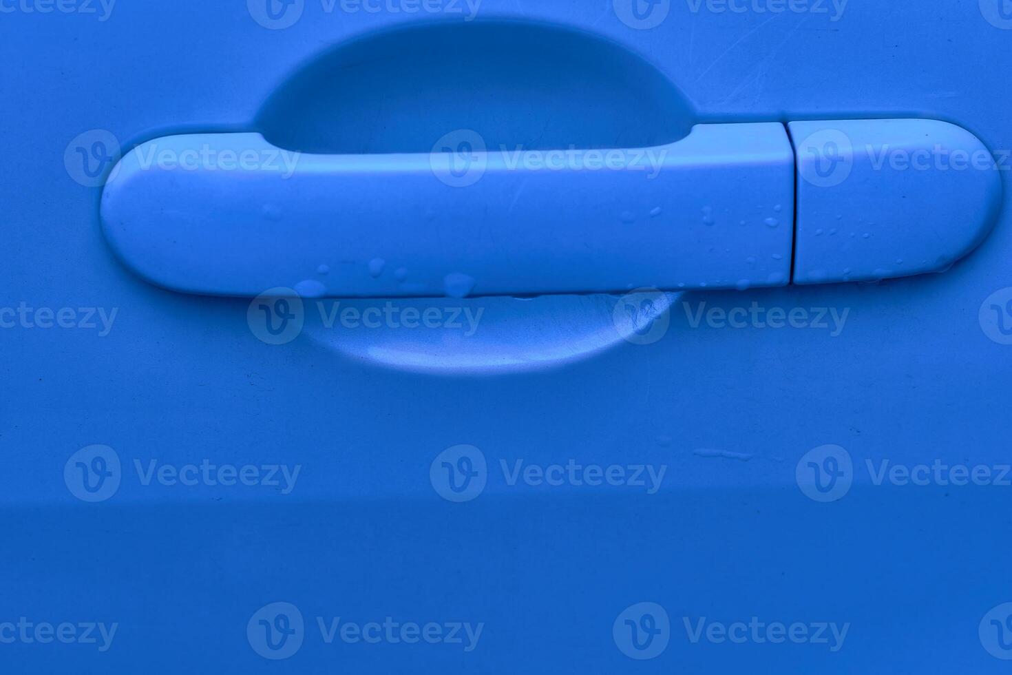 Evening blue car handle with lock, key hole after rain photo