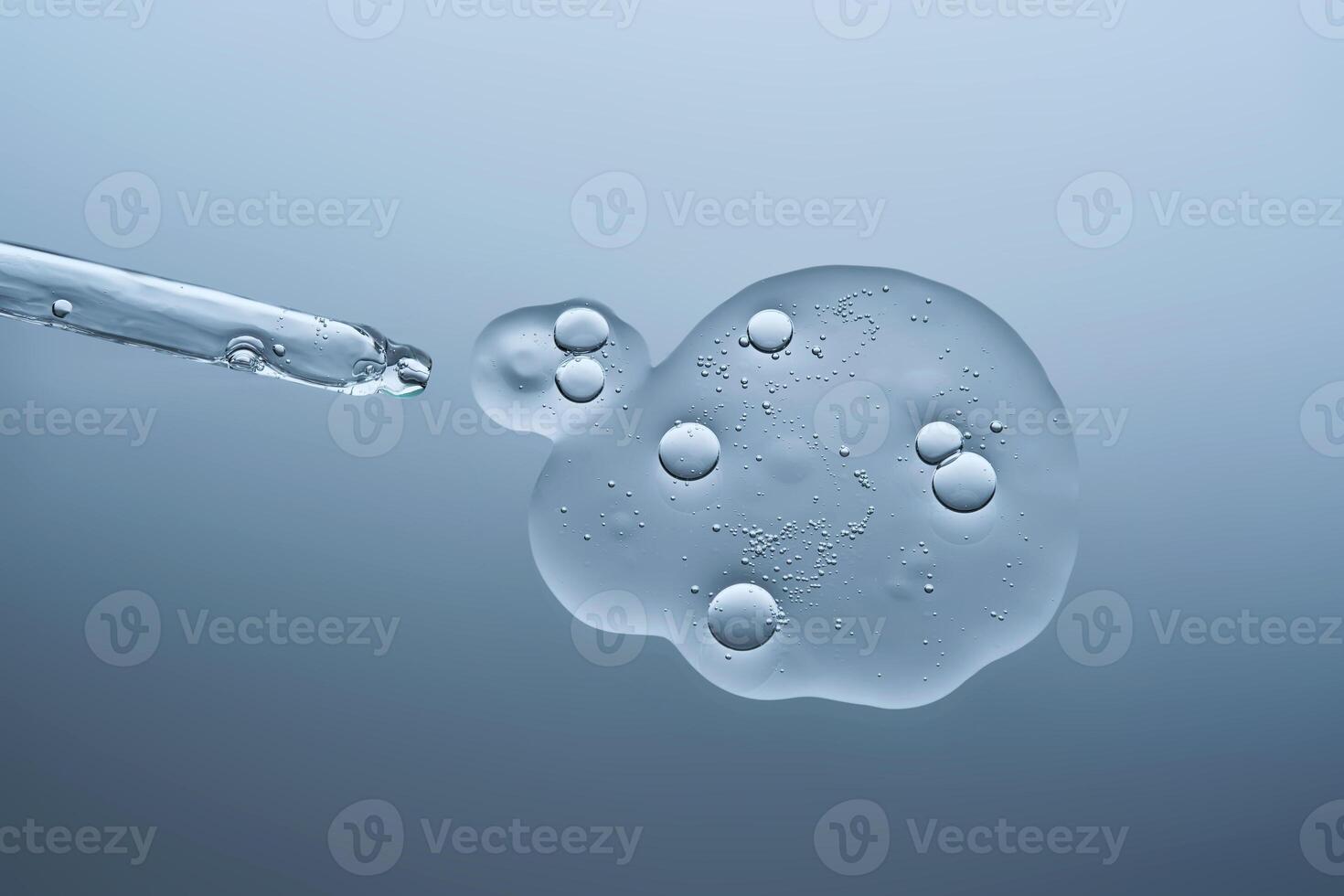 Transparent serum with bubbles and dropper dropper on a blue background. photo