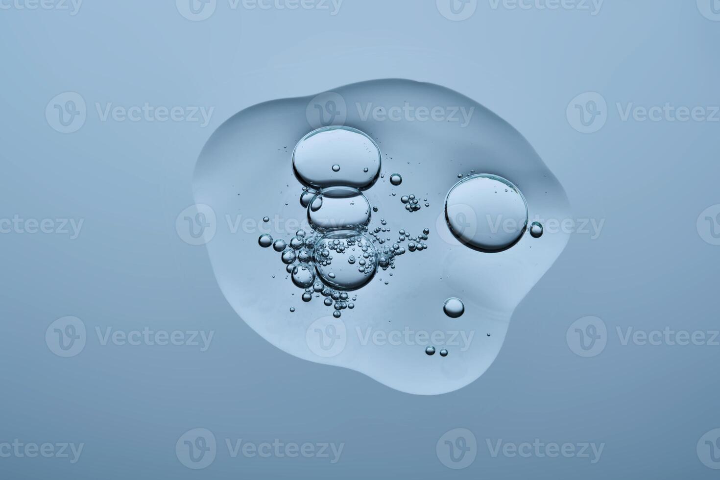 A drop of serum with bubbles on a blue background. photo