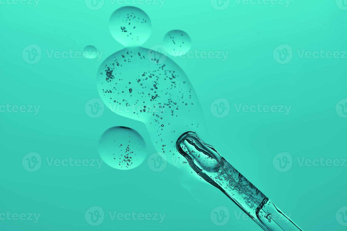 A dropper with a transparent serum texture on a green background. photo