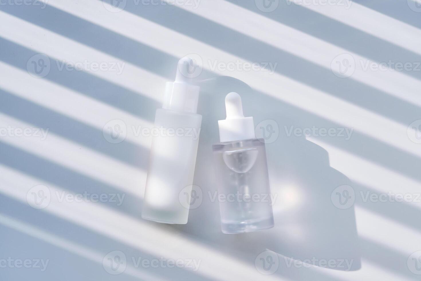 Two serums with peptides and Spicule Ampoule serum on a white background with stripes of shadows. photo