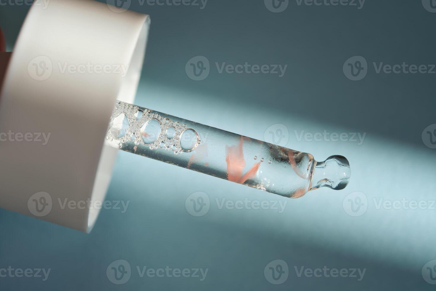 A serum pipette on a blue background. photo