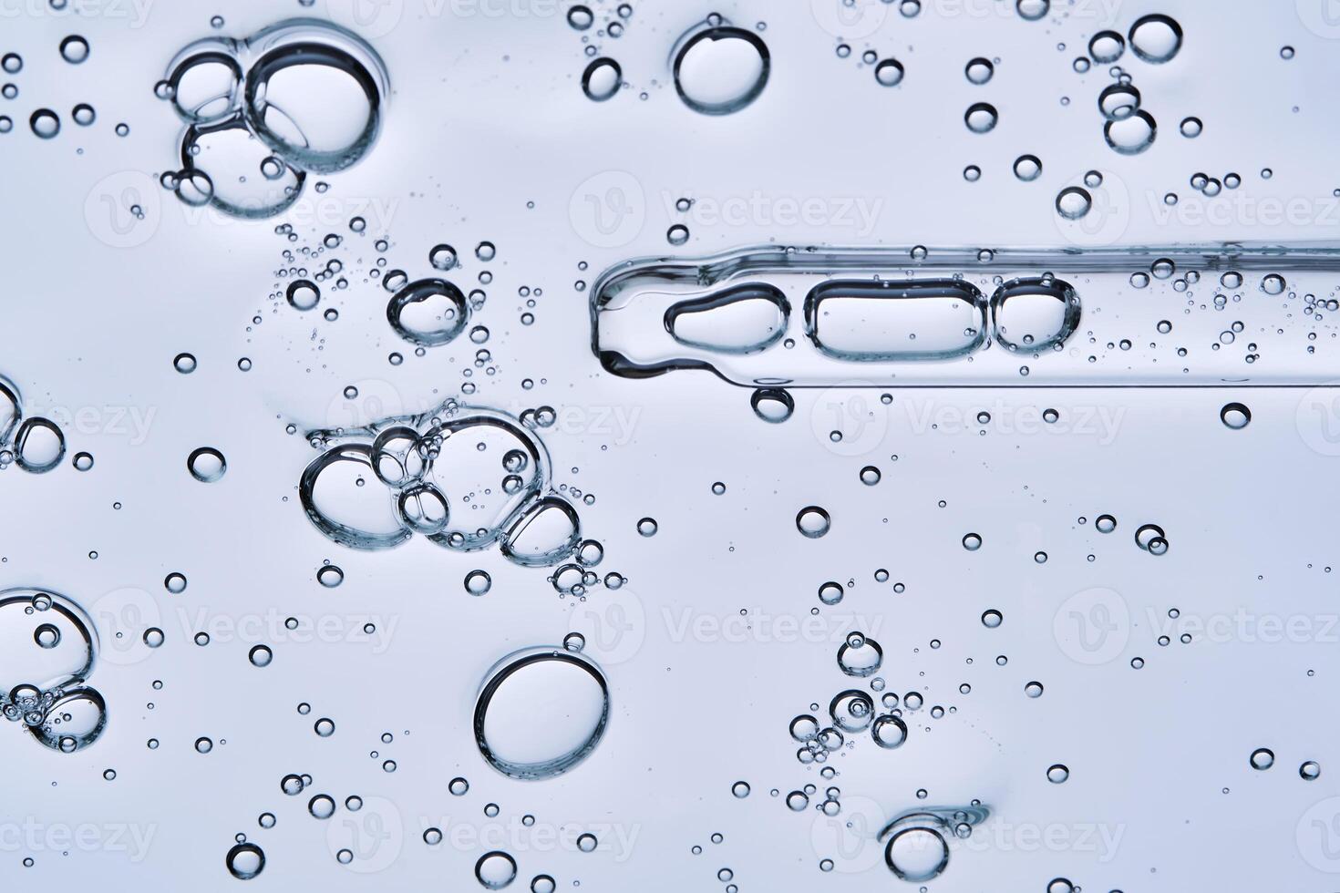 The bubbly texture of a face serum with a pipette. View from below. photo