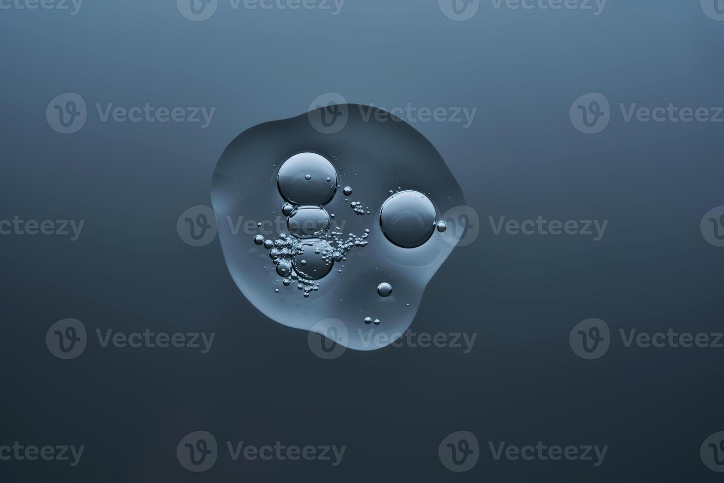 A drop of serum with bubbles on a dark blue background. photo