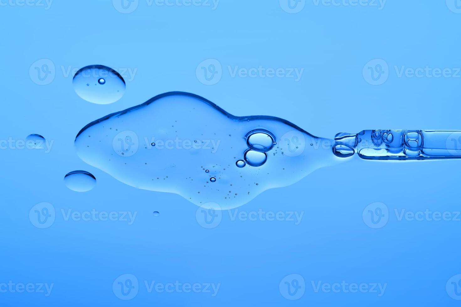 Beautiful serum texture with a pipette on a blue background. photo