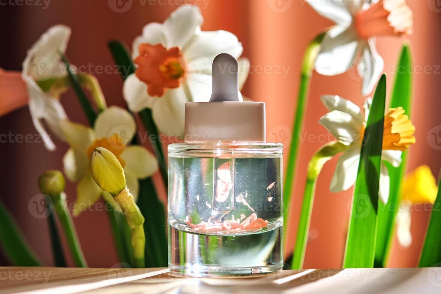 Serum bottle with petals with daffodils. photo