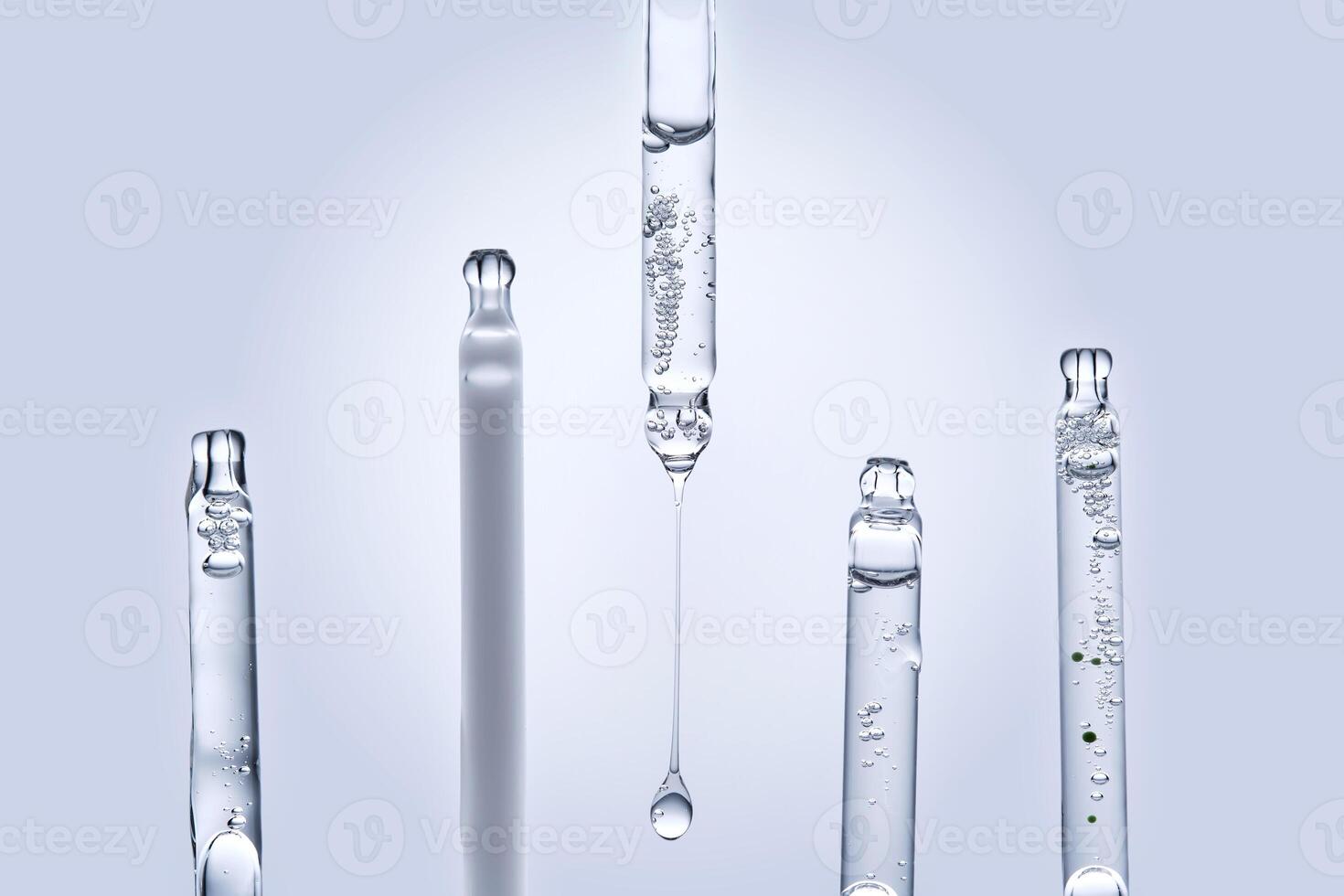 Five different droppers with facial serum in a row. photo