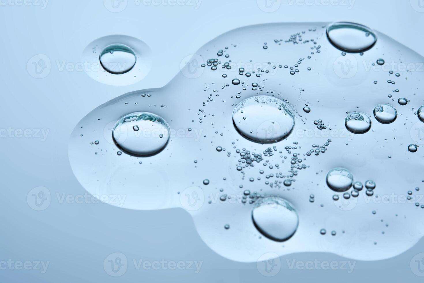 A drop of cosmetic beauty gel texture on a blue background. photo