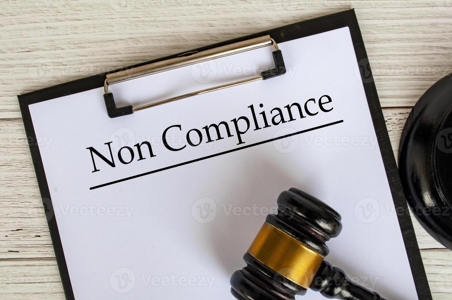 Top view of Non Compliance text on clipboard with gavel on top. Compliance concept. photo