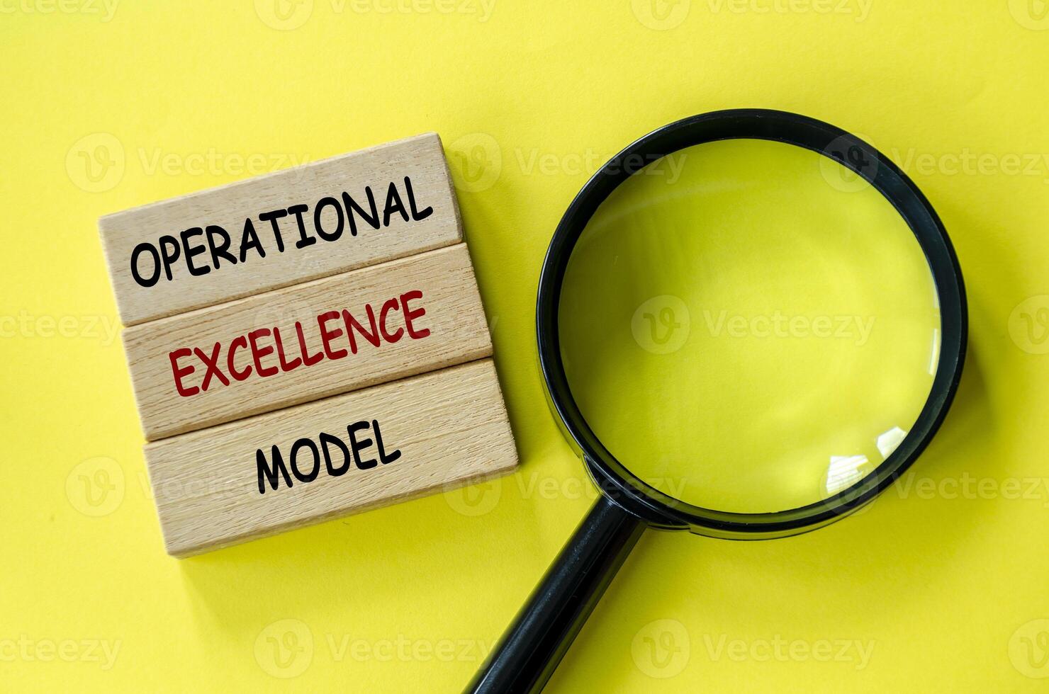 Operational Excellence Model text on wooden blocks with magnifying glass as background. Root cause analysis concept photo