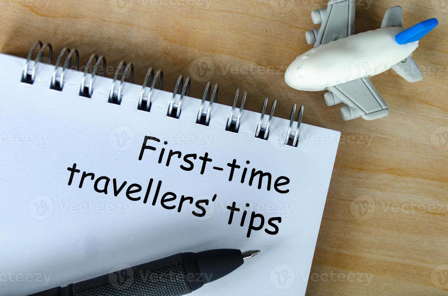 Top view of First Time Traveller tips text on white notepad. Getaway concept. photo