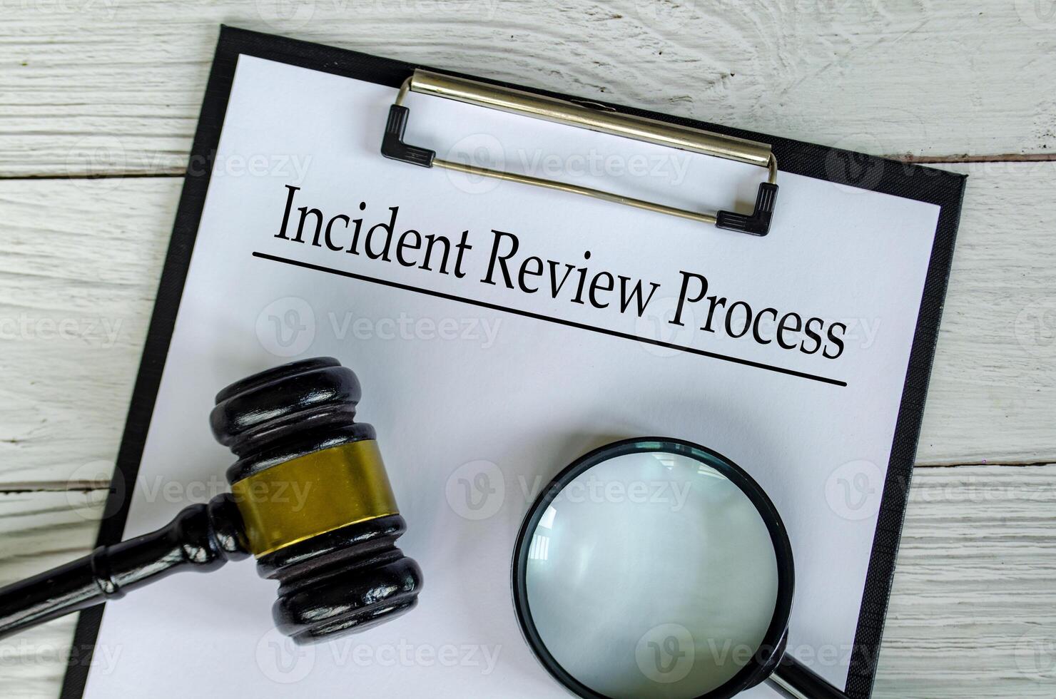 Top view of Incident Review Process text on white paper clipboard with gavel and magnifying glass photo
