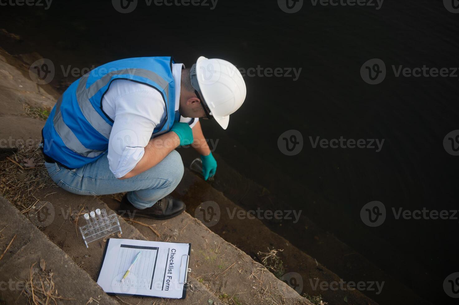 A water resource worker is collecting water sample in a river photo