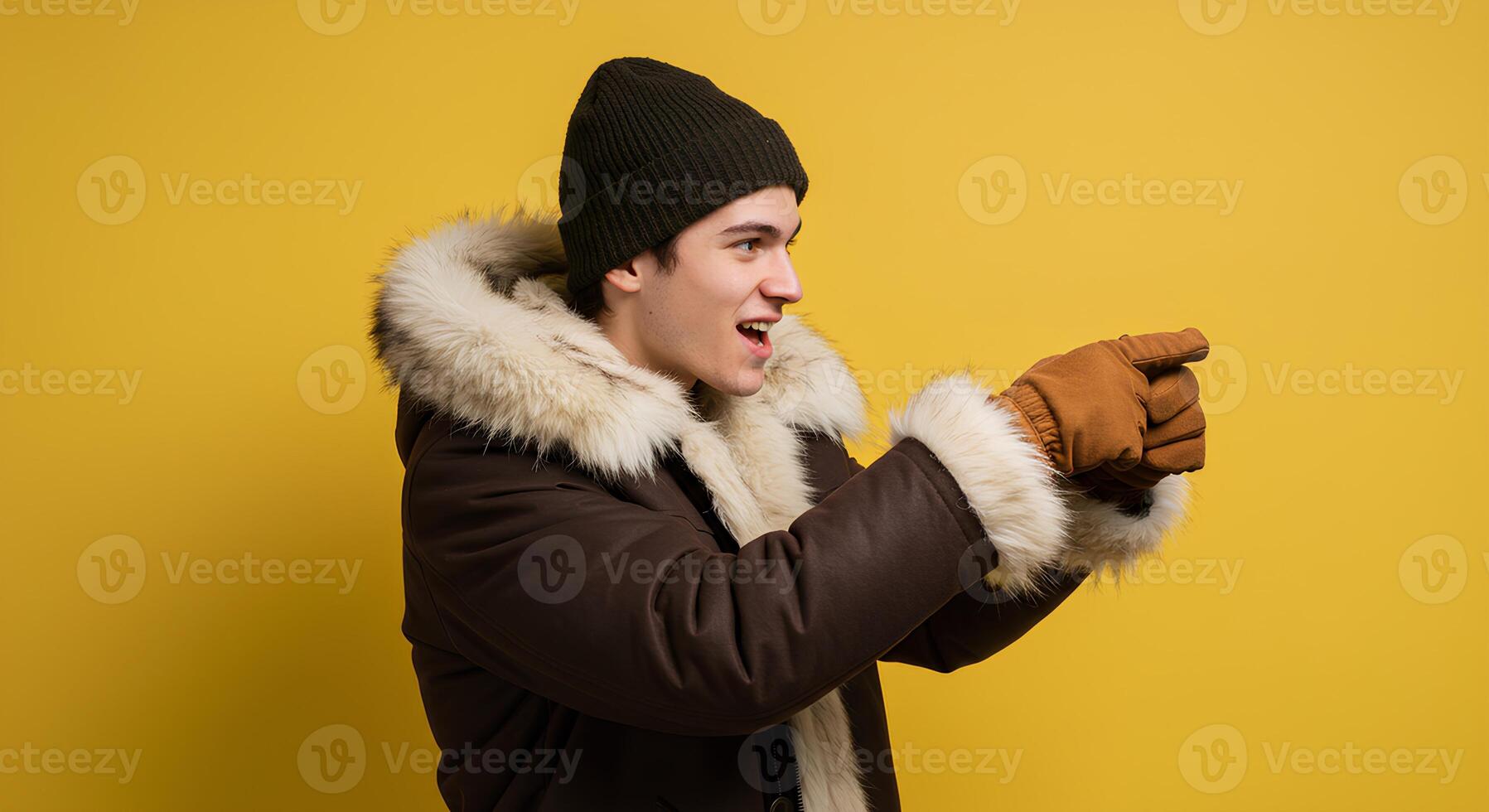 Man in a Brown Parka and Knitted Hat Points Enthusiastically photo
