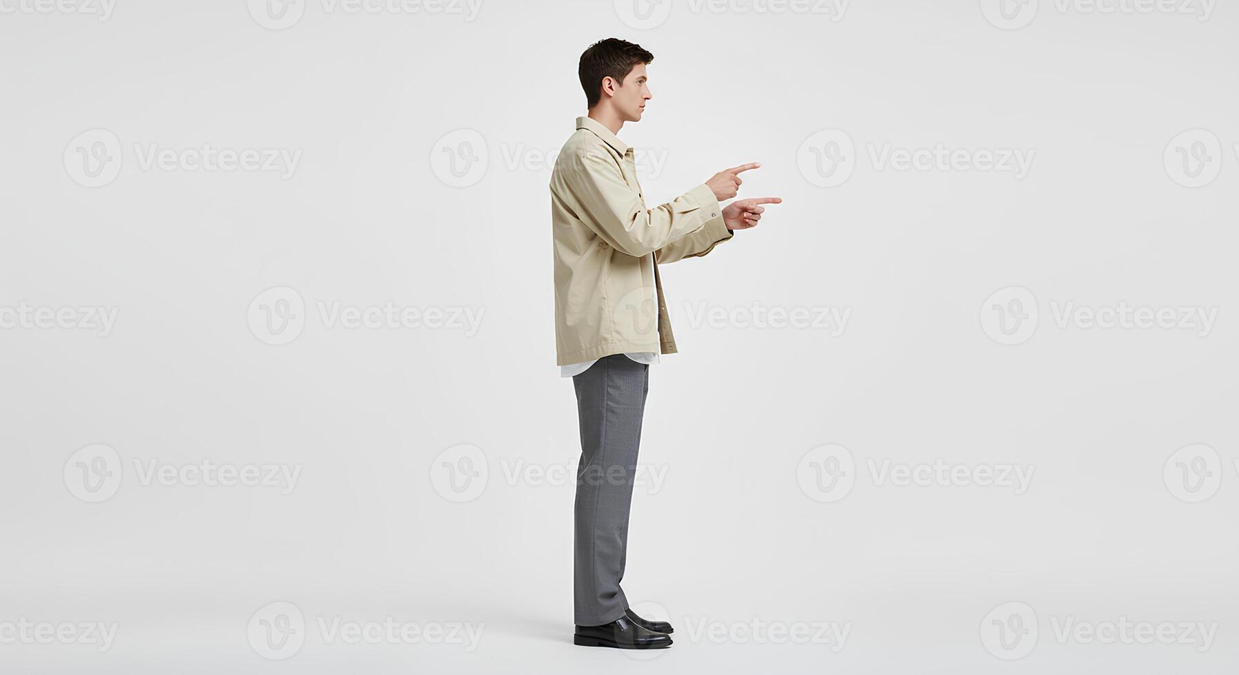 Man in Beige Jacket and Gray Pants Pointing, Studio Portrait photo