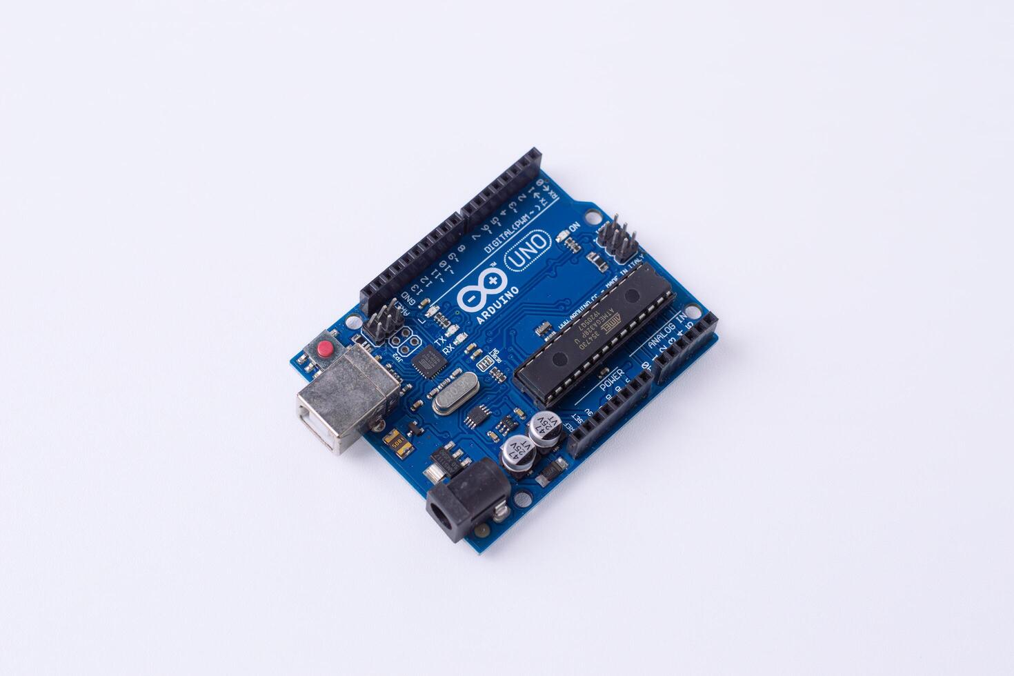Malang, March 24, 2025. Side view of Arduino Uno microcontroller board on white background. DIY electronics, robotics, embedded system, prototyping hardware, open-source platform for coding. photo