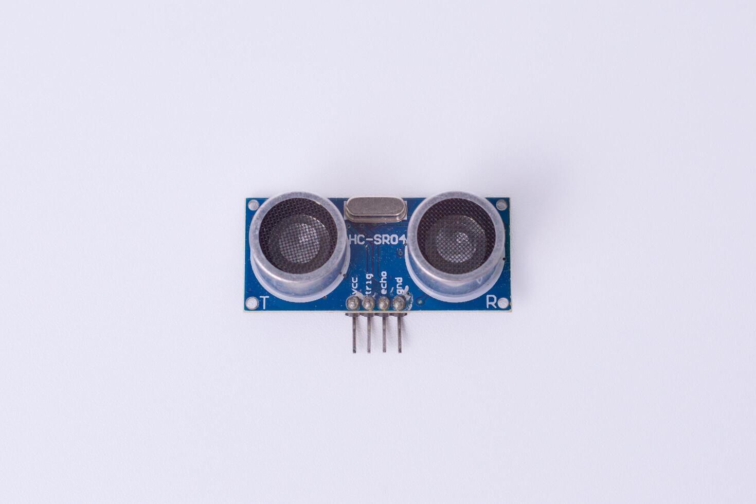 Malang, March 24, 2025. Front view of HC-SR04 ultrasonic sensor module on white background. Distance measuring sensor for Arduino, robotics, obstacle detection, DIY electronics. photo