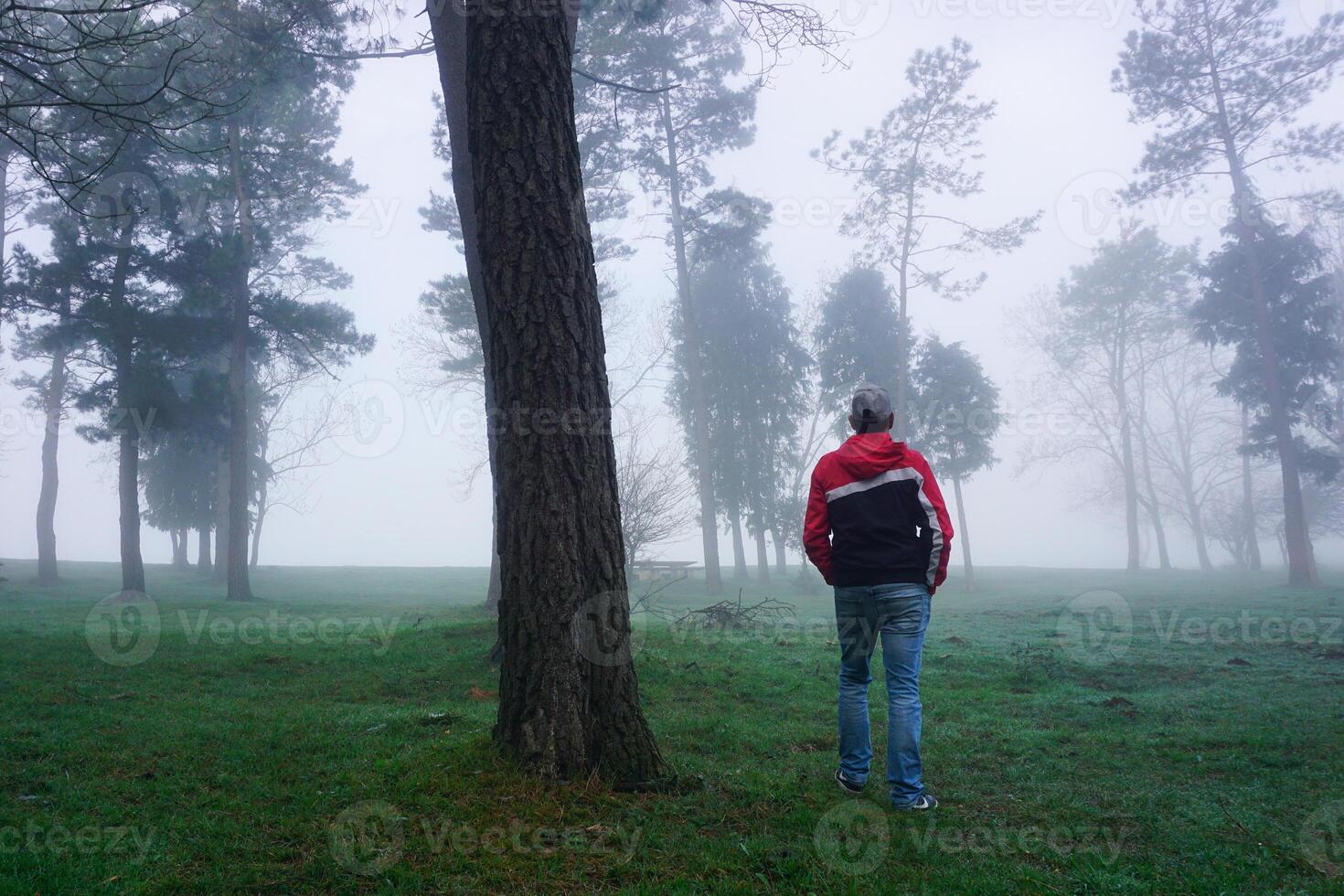 man trekking in the mountain with fog in winter photo