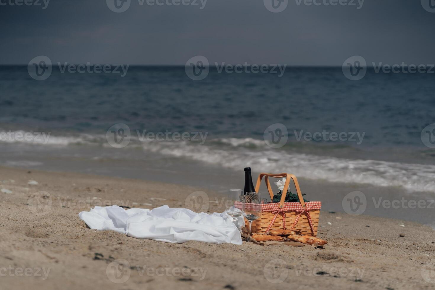 Minimalist coastal picnic setup with wine basket and khachapuri on sand. Beach Picnic by the Ocean photo