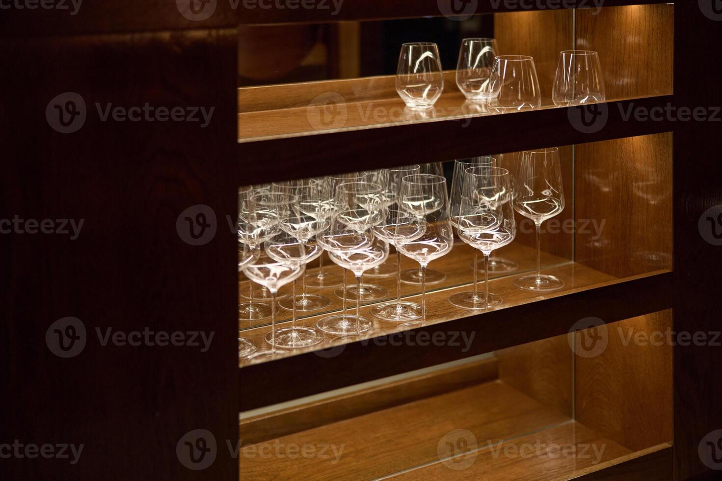 Clean wine glasses are in the wine cabinet in restaurant, local illumination photo