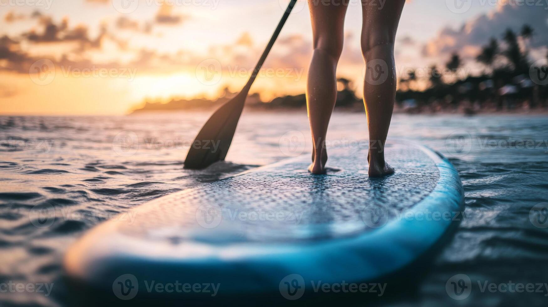 Experience summer adventure with stand up paddle boarding on a sandy beach during sunset at a tropical paradise photo
