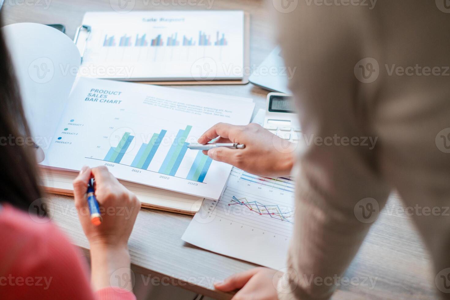 Professionals reviewing sales charts and graphs for business strategy and growth in a modern office environment. photo