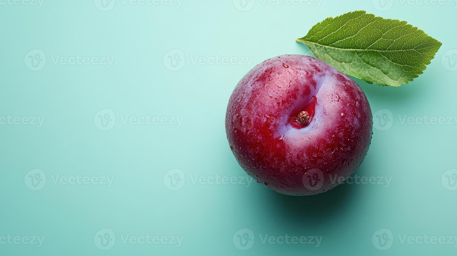 A plump plum resting on a mint green background, creating a vibrant and artistic visual ideal for food-related content, marketing materials, or culinary blogs. photo