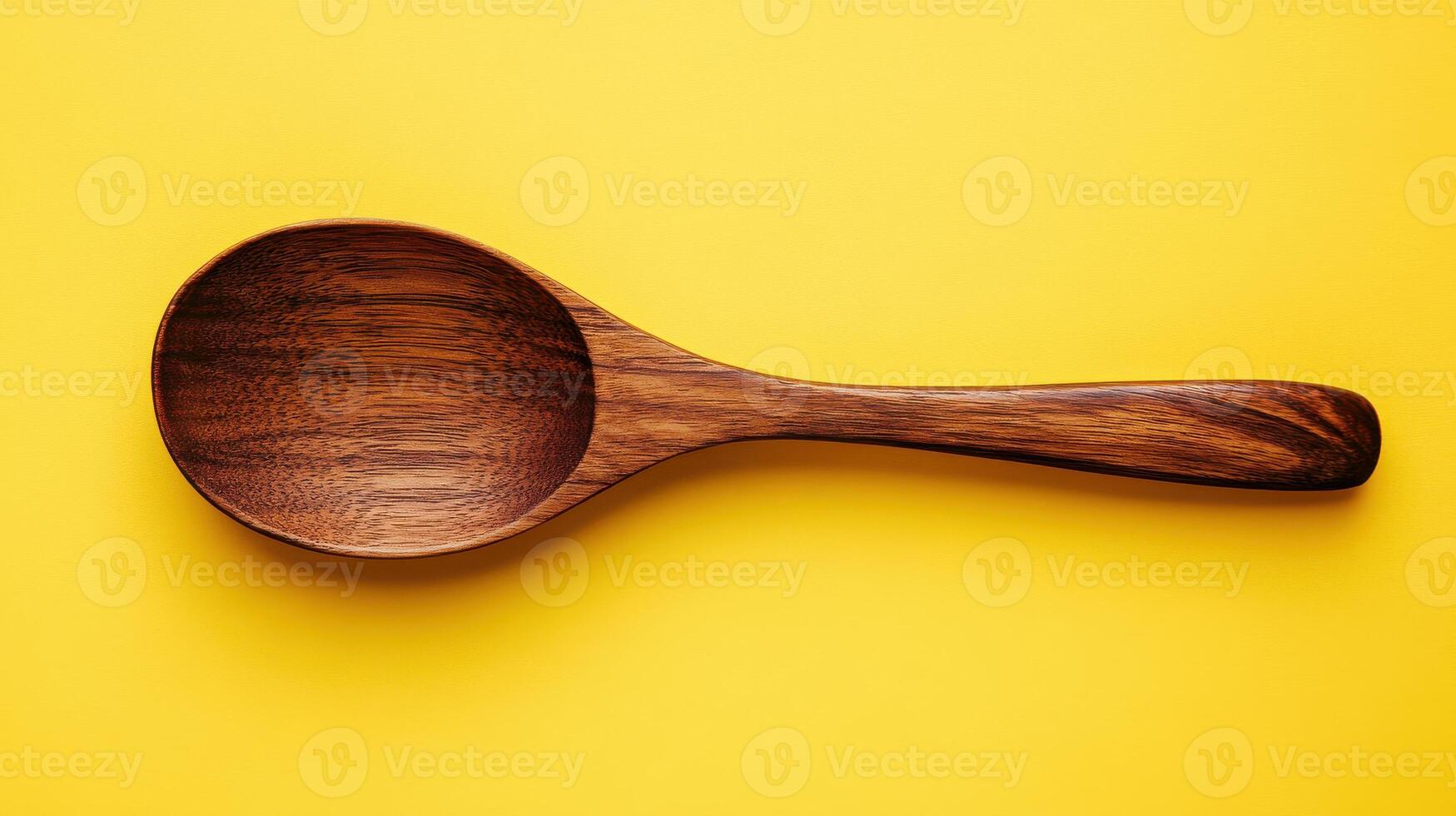 A Simple Wooden Spoon on a Solid Yellow Background Perfect for Kitchen Decor or Culinary Use photo