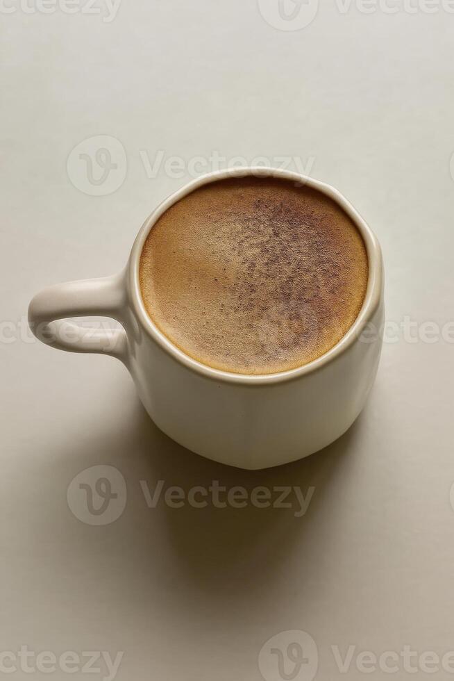 Close up of a cappuccino in a matte light ceramic cup with an irregular rim. photo