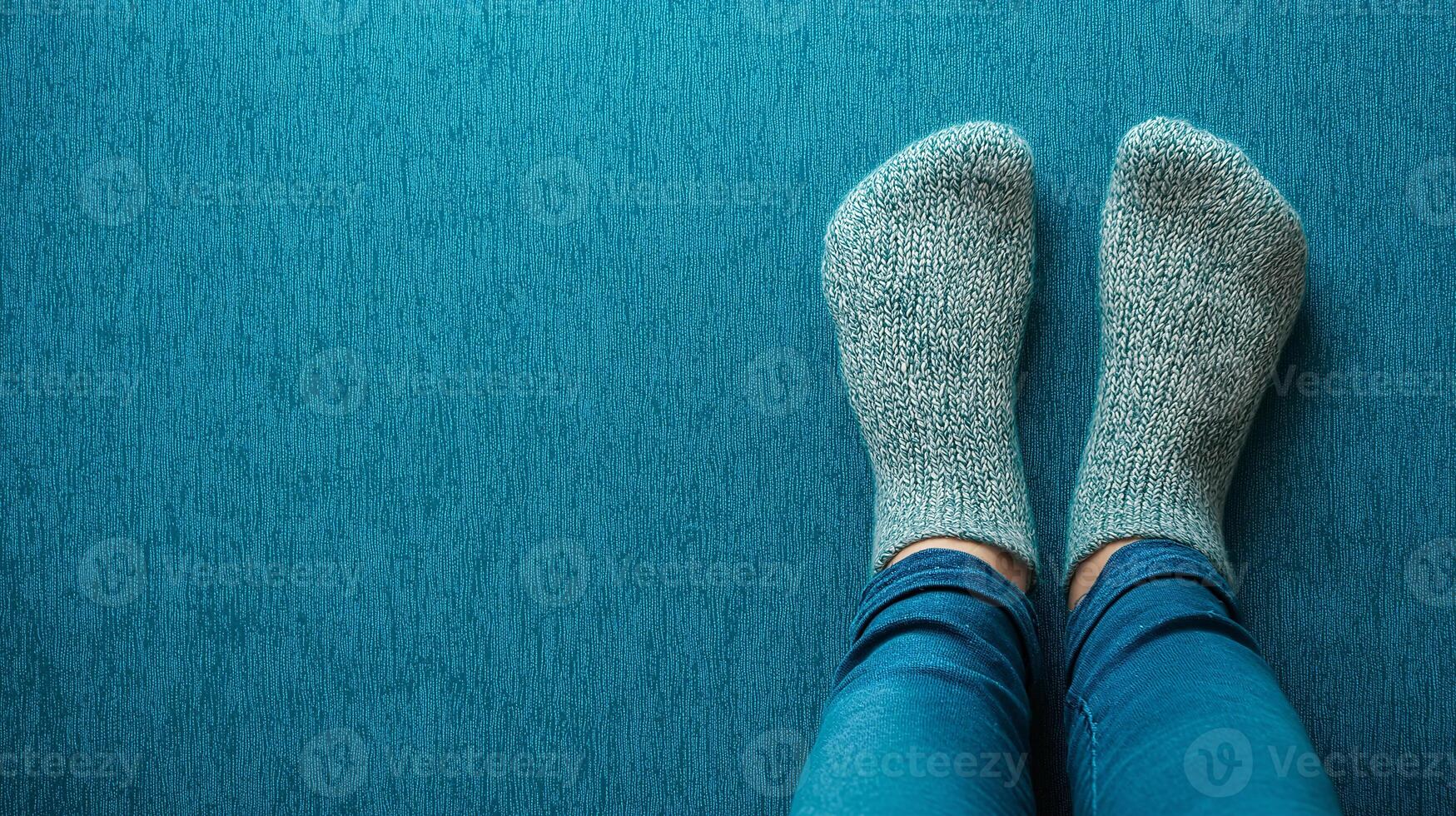 A person wearing blue jeans and socks on a blue carpet photo