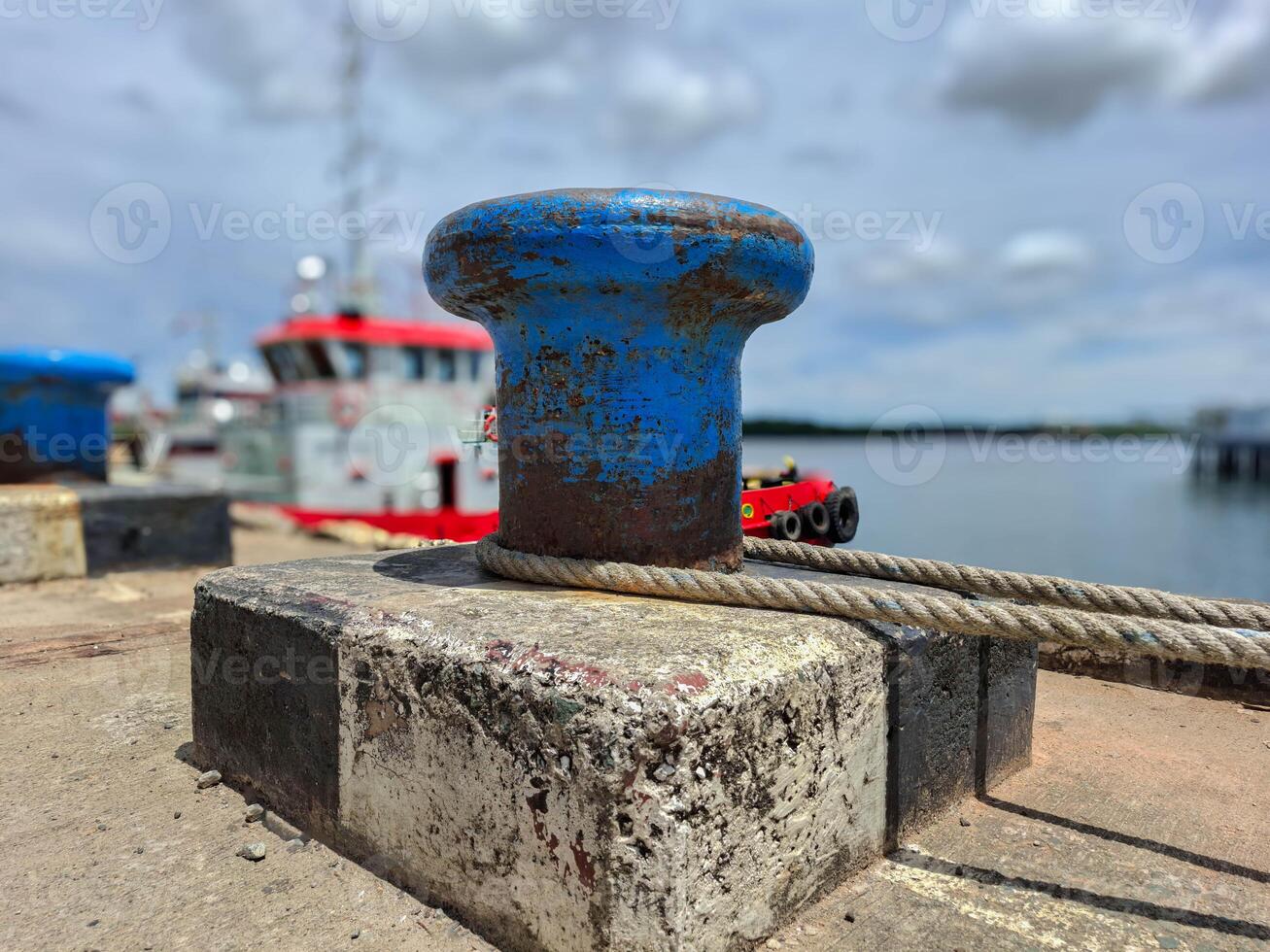 Mooring bollard with rope to tie the ship when docked in the harbor photo
