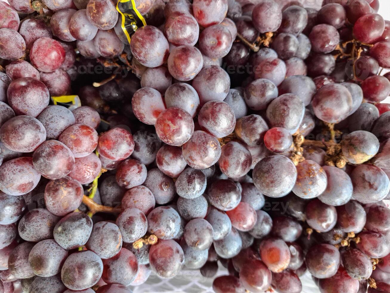 A bunch of grapes are sitting on top of each other photo