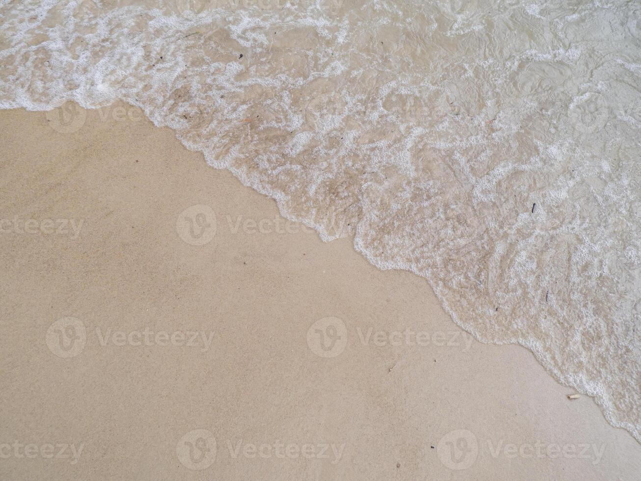 A person walking on a beach with a surfboard photo