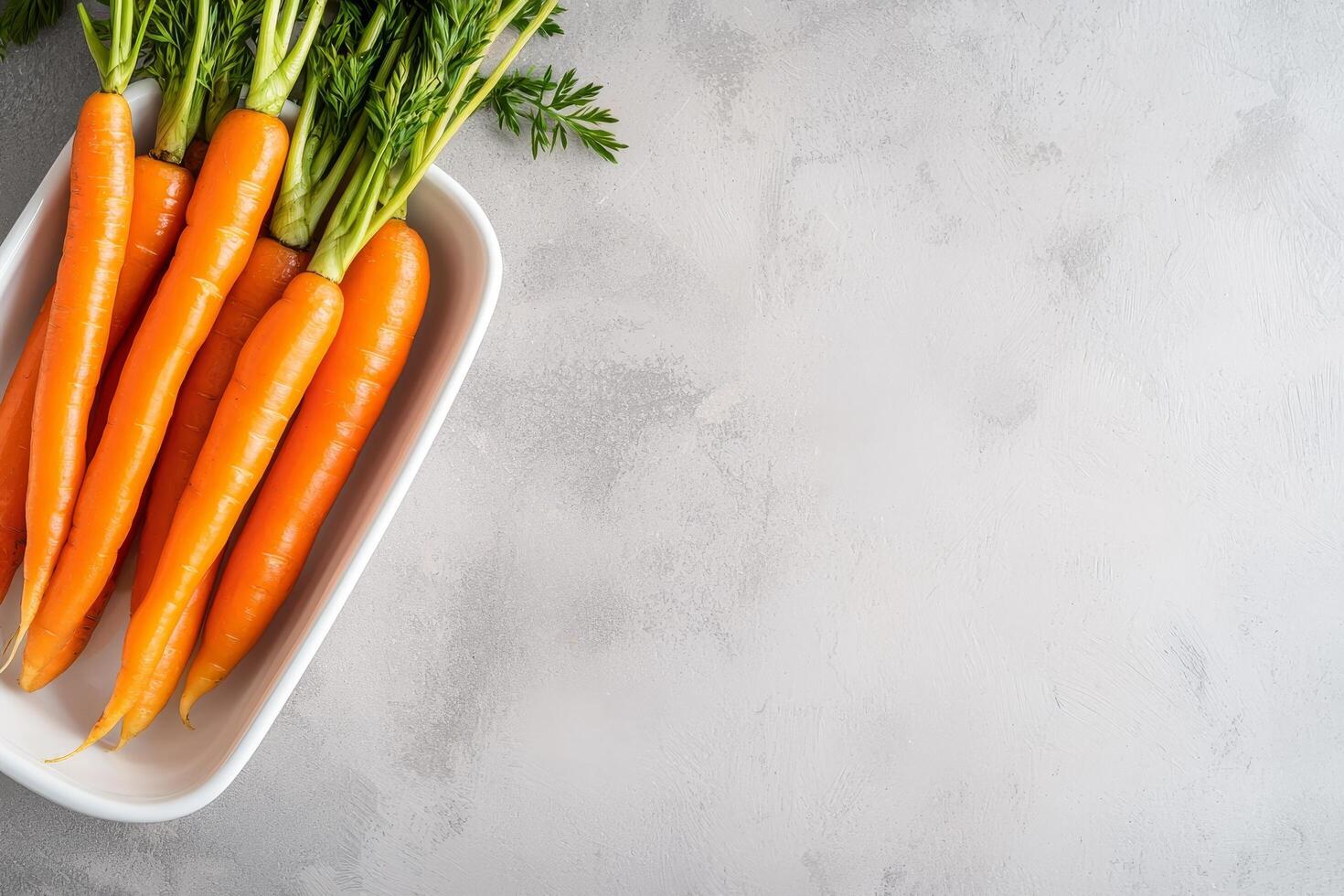 Fresh carrots arranged in a bowl on a textured surface. photo