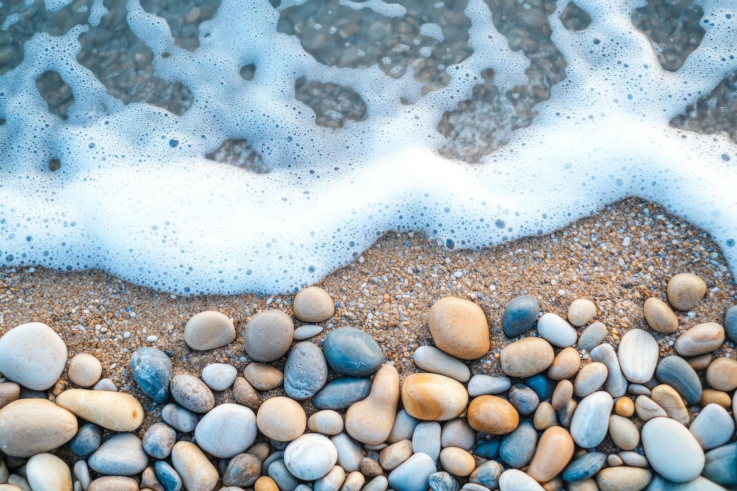 Beach stones with waves and foam on the shoreline. photo