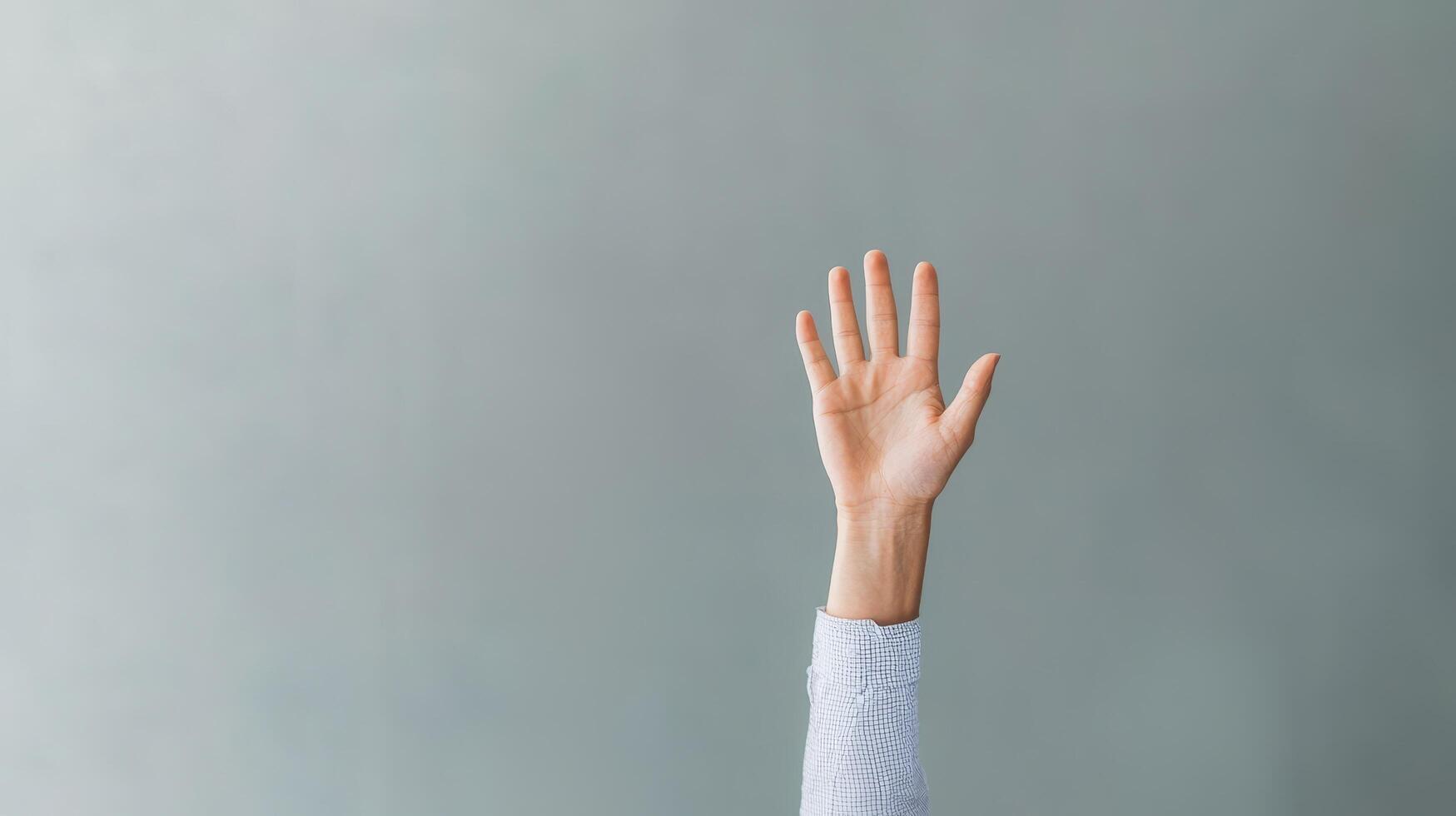 Hand raised against a muted gray background. Communication skills persuasion. photo