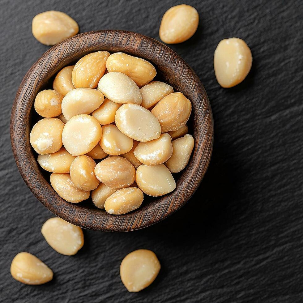 Bowl of seeds on a dark surface, some scattered around. photo