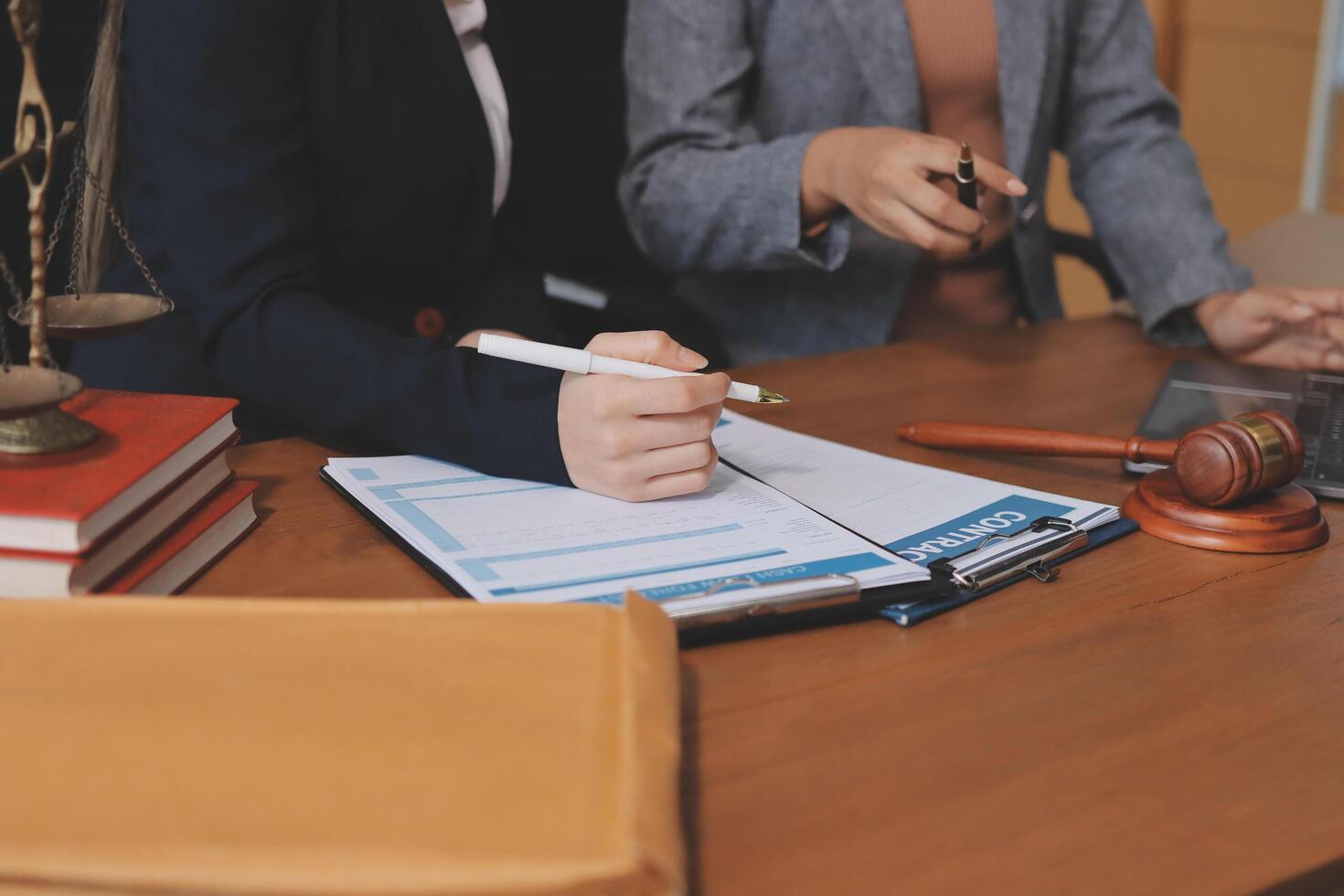 Two business people sitting at a desk with a notebook and a gavel photo