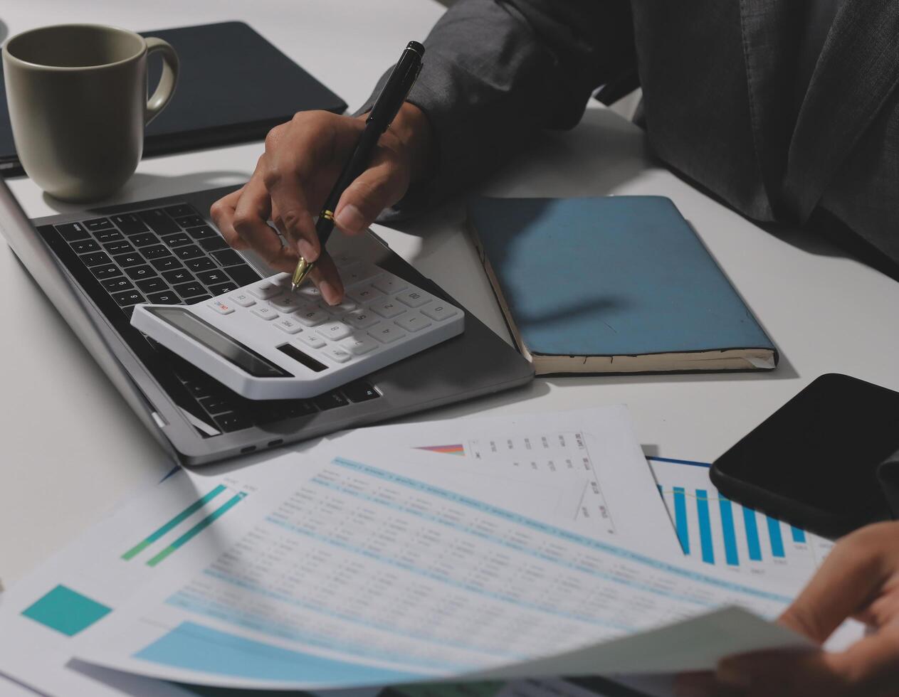 Businessman using calculator and laptop to calculate business expenses photo