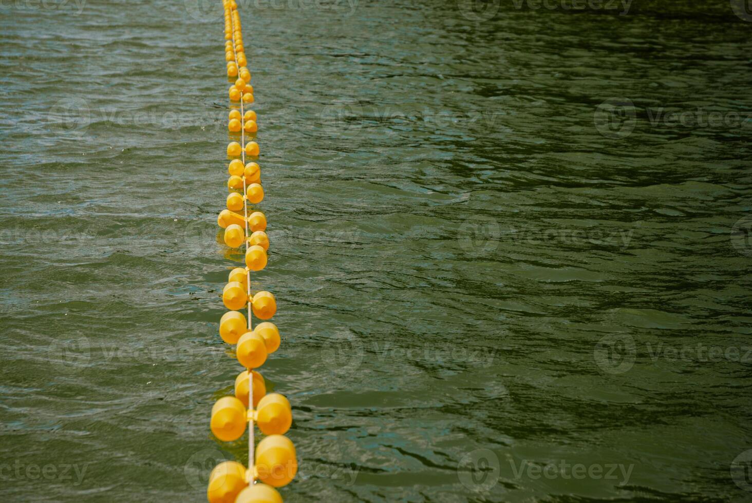 Yellow buoys floating on water surface for summer safety and navigation. Weekend concept near the forest and lake photo