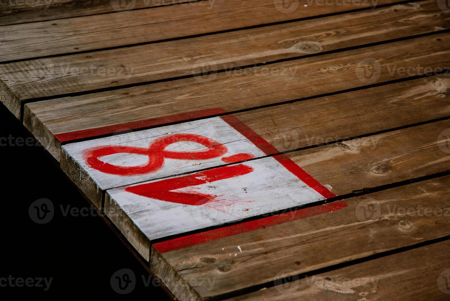 Weathered wooden dock with number eighteen painted red and white. Weekend concept near the forest and lake photo